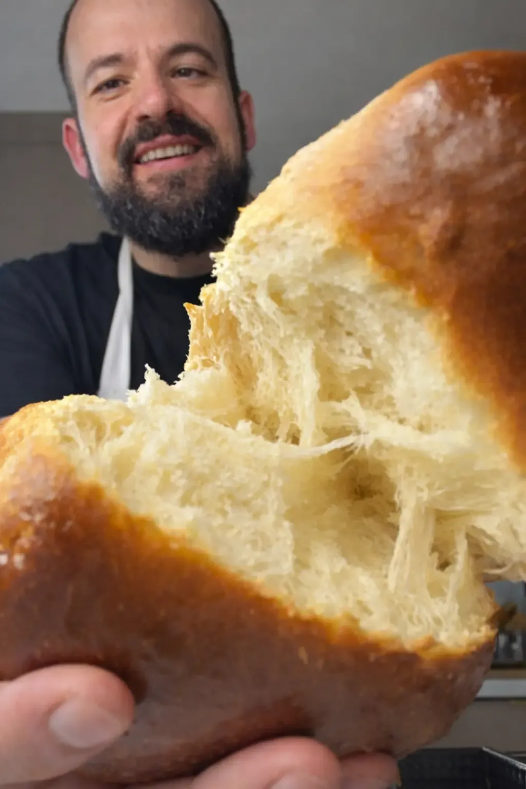 Japoński chleb mleczny shokupan rozerwany na pół, z miękkim i puszystym środkiem, trzymany w dłoniach przez Michała Gotuje.